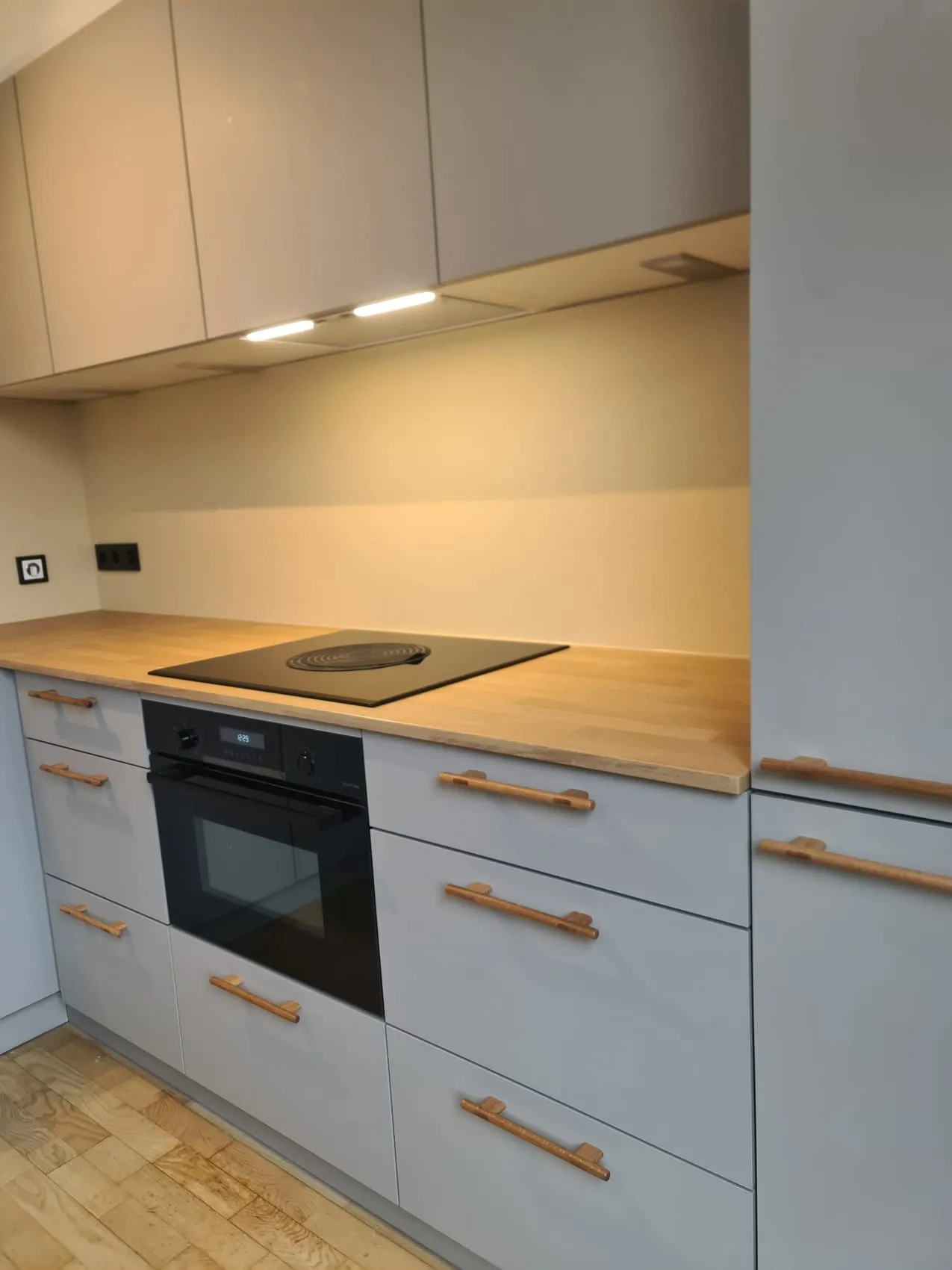 Licht blauwe keuken met eiken werkblad en een naadloze beige rugwand