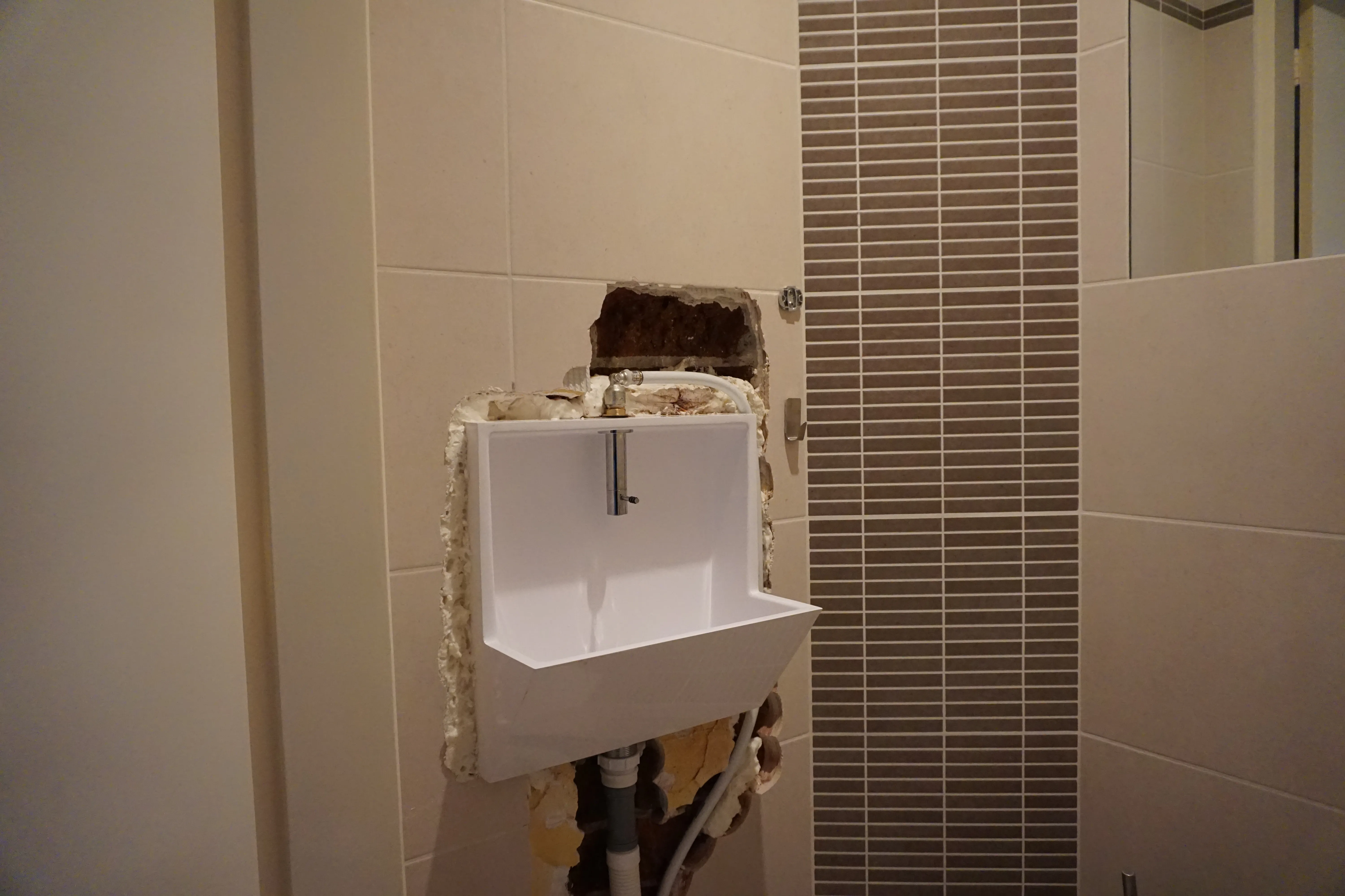 Een crèmekleurige rugwand die past bij de bestaande tegels in een toilet — voor de plaatsing