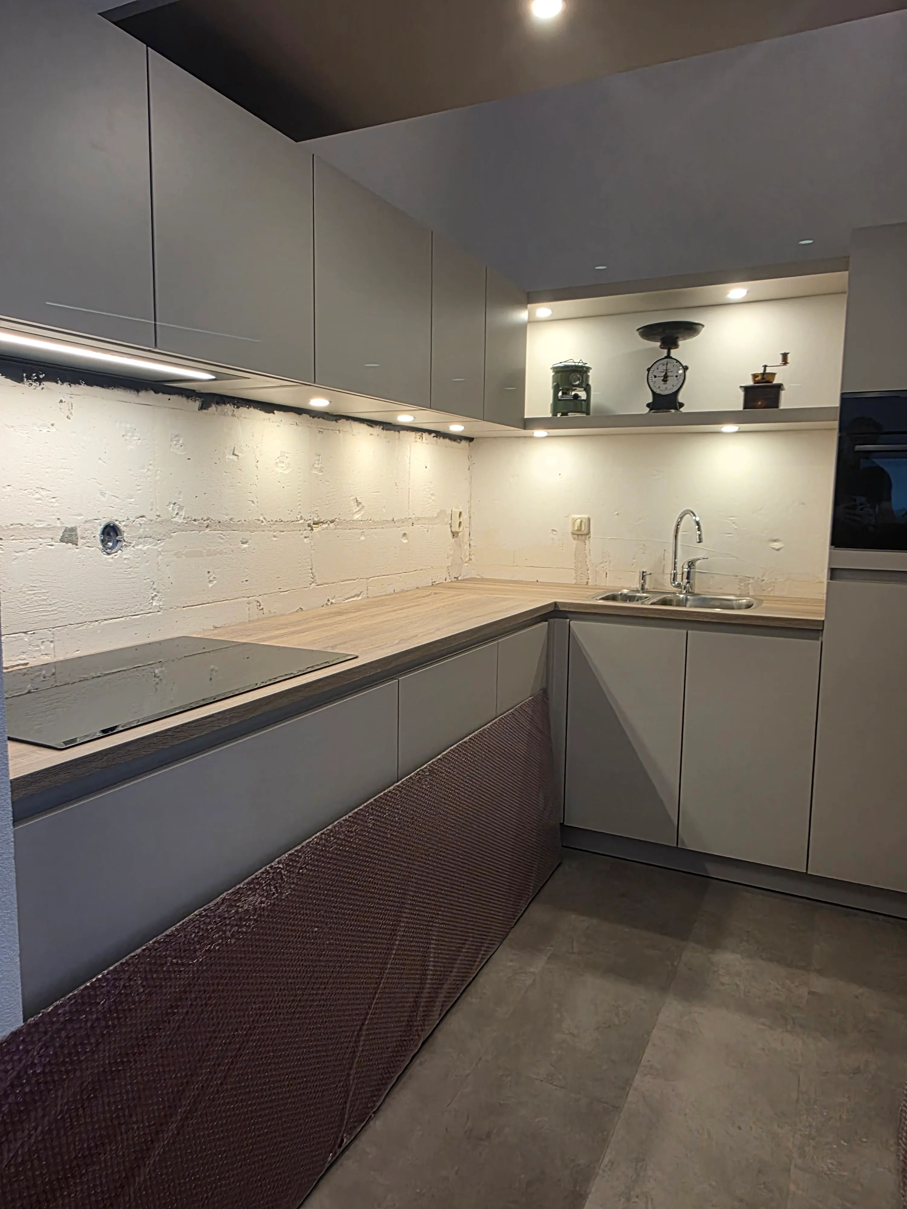 Een rode rugwand voor een lichte keuken met houten werkblad — voor de plaatsing