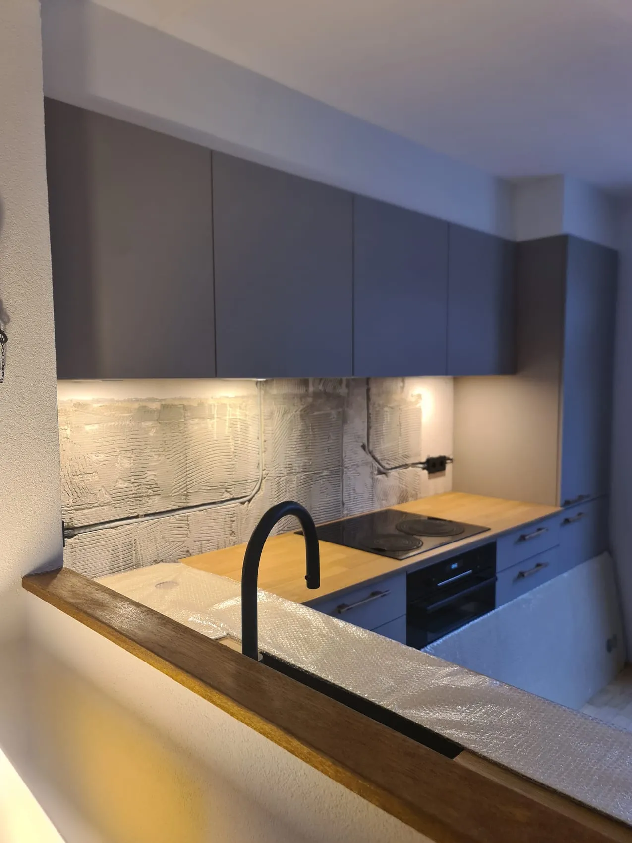 Beige rugwand op een beschadigde muur, zonder breek- en stucwerk — voor de plaatsing
