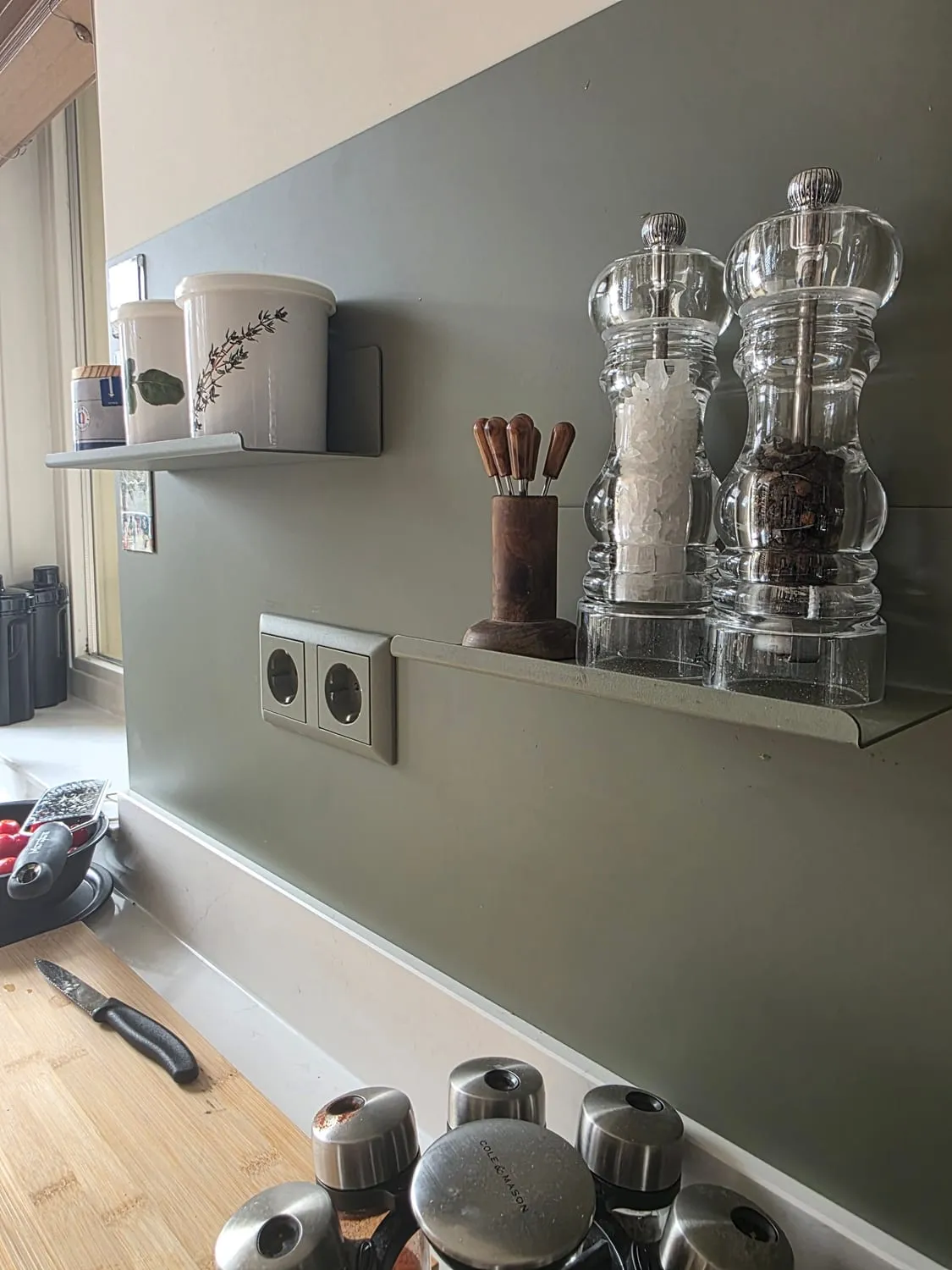 Magnetische planchets met kruiden, zout- en pepermolens in een keuken
