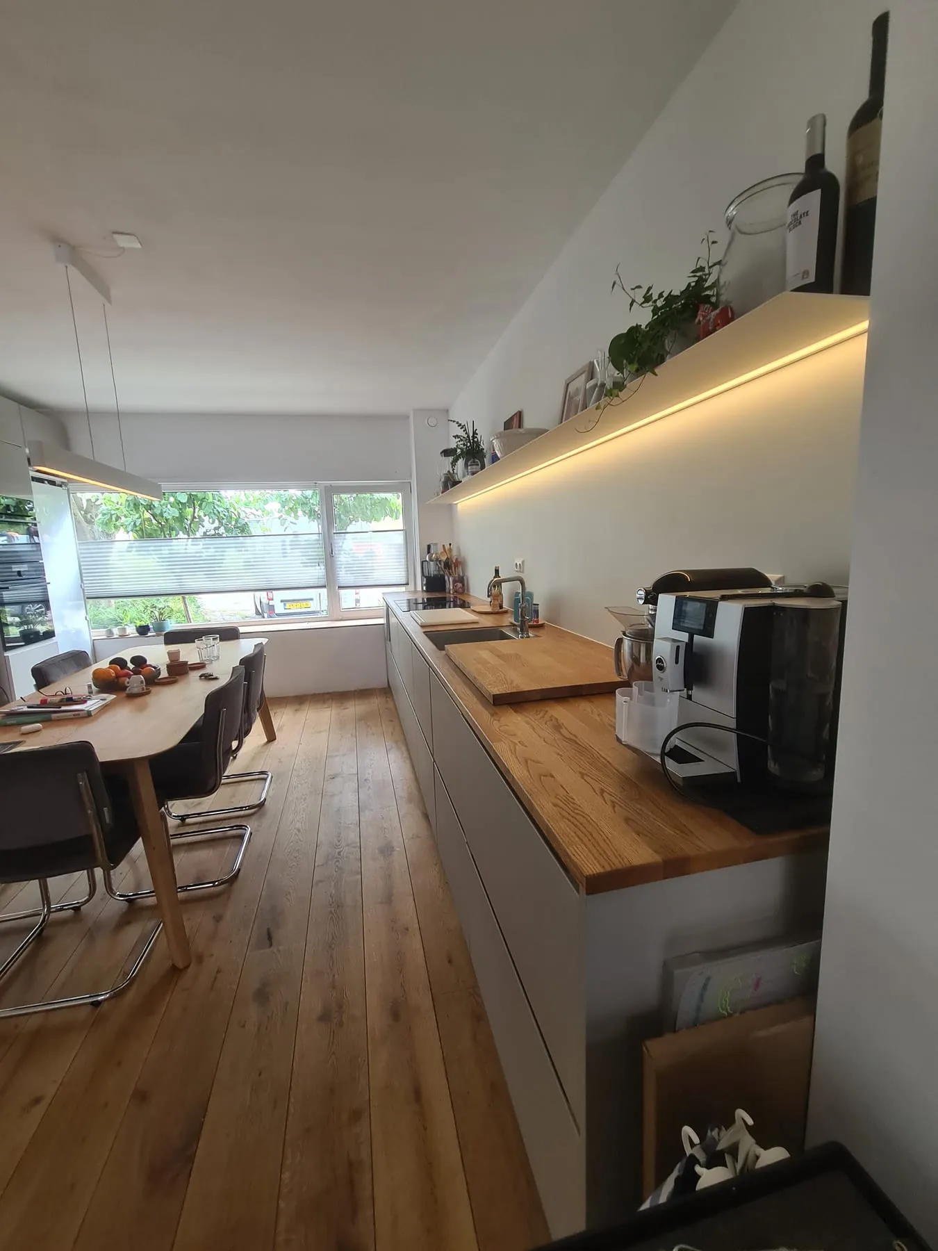 Naadloze aluminium rugwand met houten werkblad in een lichte keuken